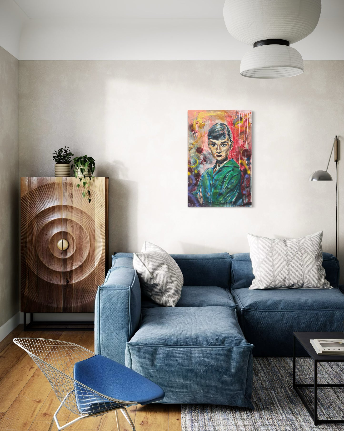 Audrey Hepburn portrait above blue cozy couch