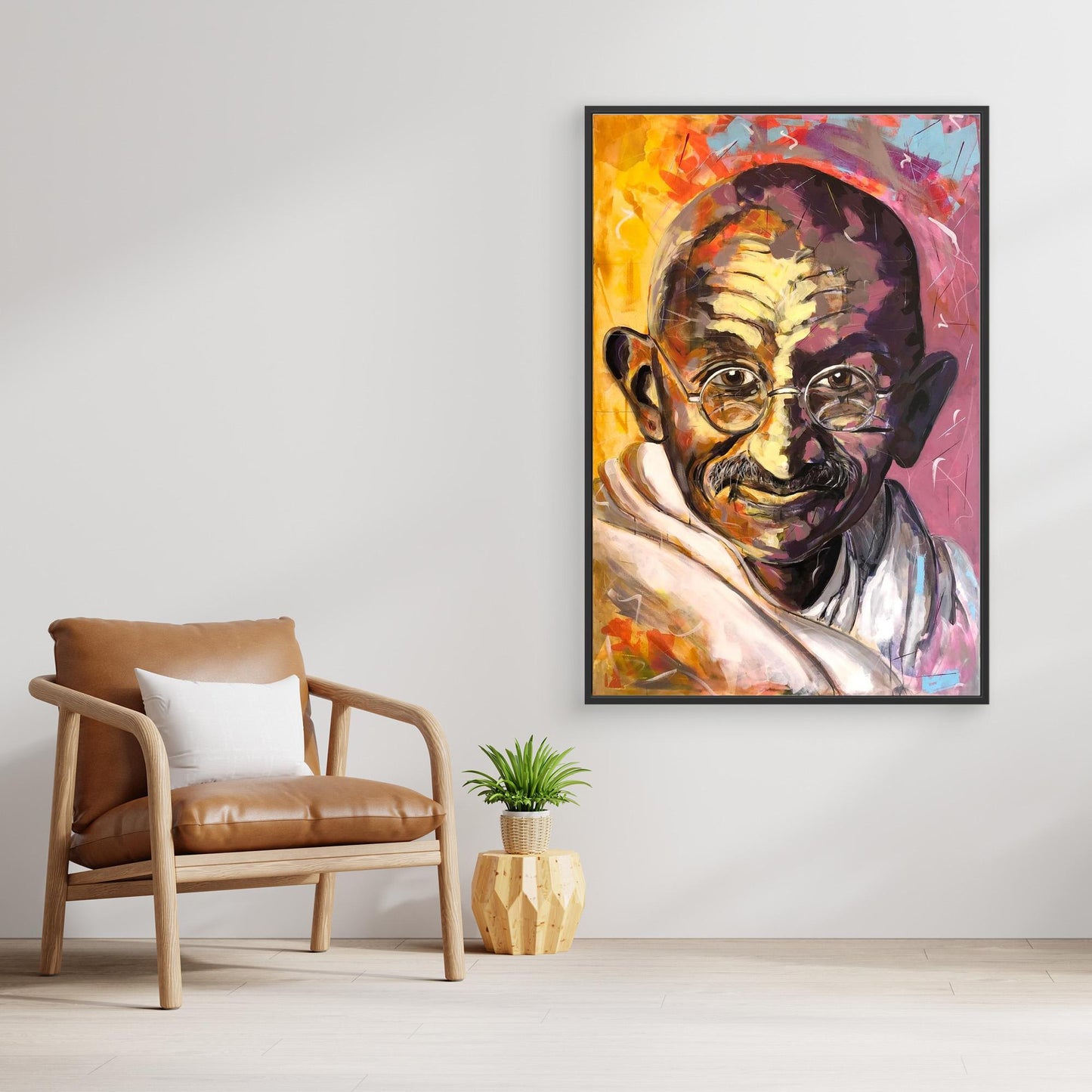 GANDHI canvas print displayed above chair