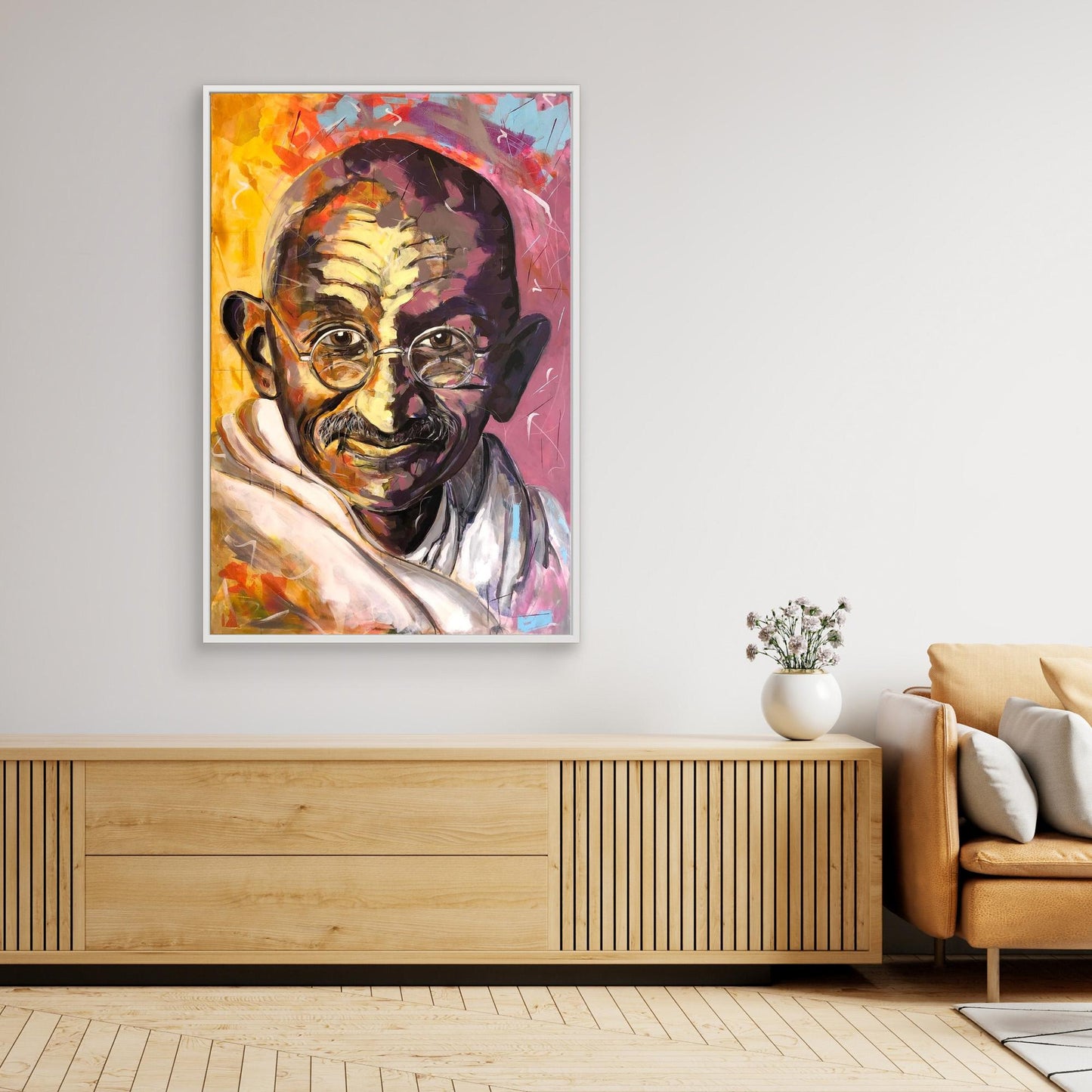 GANDHI canvas print displayed above beige sideboard
